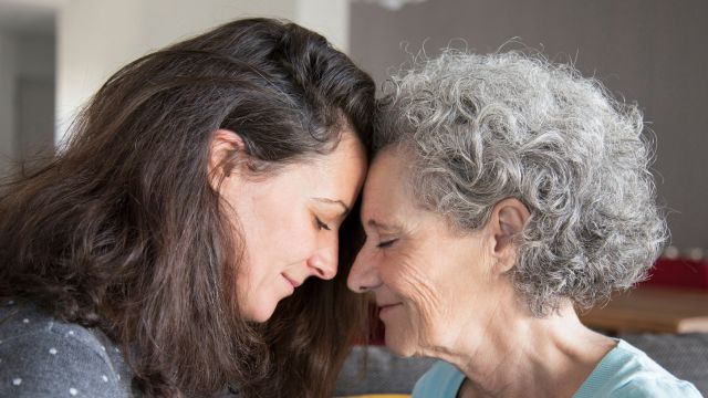 grandmother and mother touching foreheads together