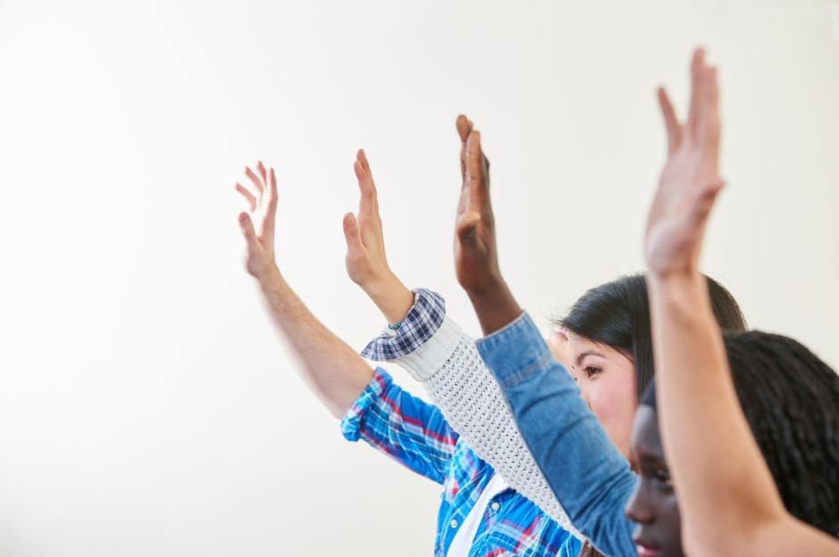 people raising their hands in class
