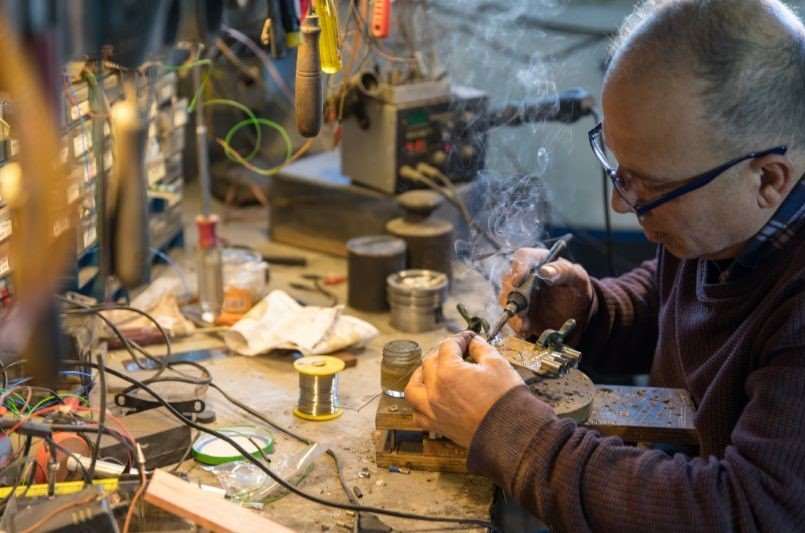 old man working with soldering tools